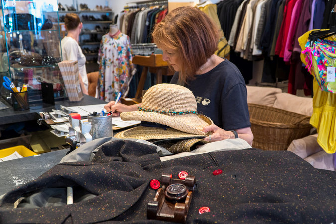 Linda Frankel, of Artful Transitions NYC, in a Housing Works store in Manhattan, filling out forms to donate a client’s belongings. Credit Emon Hassan for The New York Times